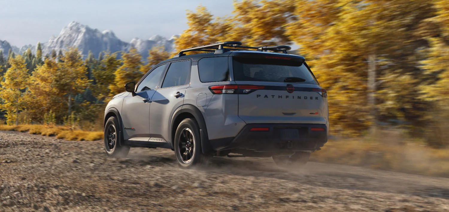 2026 nissan pathfinder rear three quarter view driving forest trail